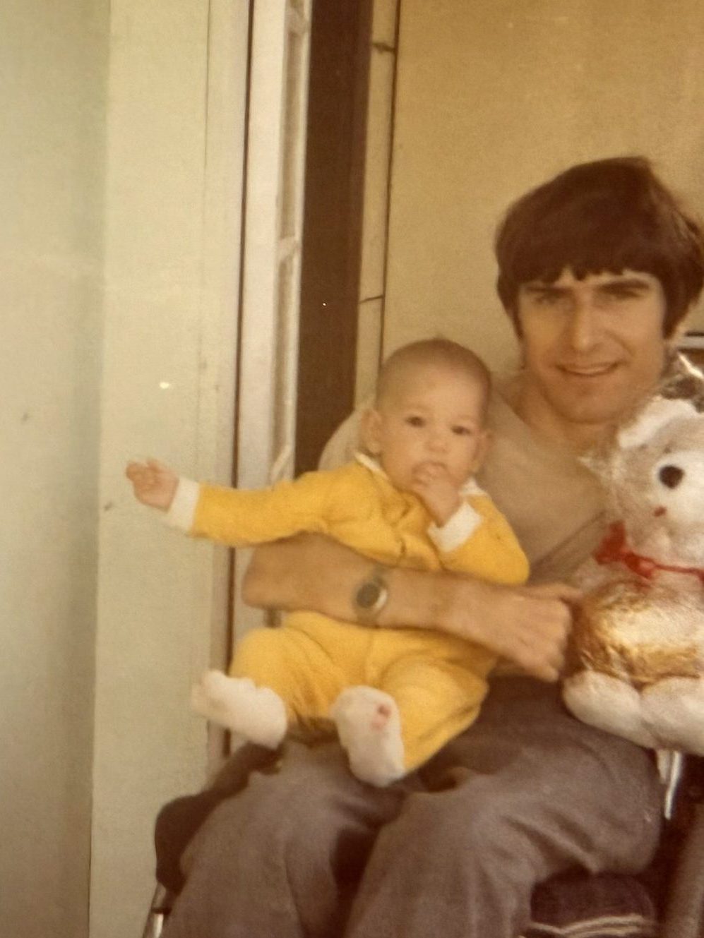Greg Kidd holds his adopted daughter Moana in his right arm, Queensland 1983